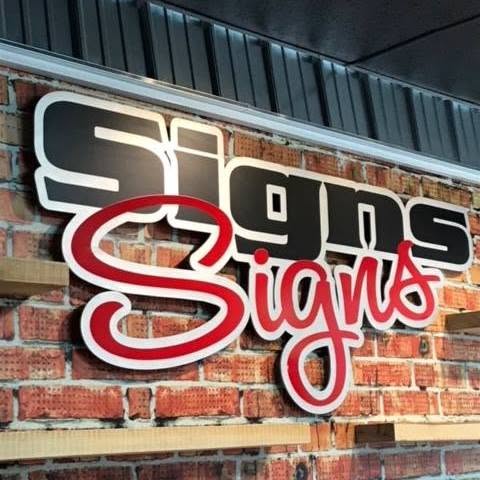 Signs Signs storefront sign mounted on a brick wall